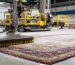 Professional hand-washing process by oriental rug cleaners near me, showing a technician in green gloves using a soft brush to clean a detailed floral Persian rug.
