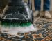 Master artisan gently hand-washing a vibrant, intricate Persian rug with a soft brush and rich organic lather, showcasing expert Iranian carpet cleaning in Berkeley.