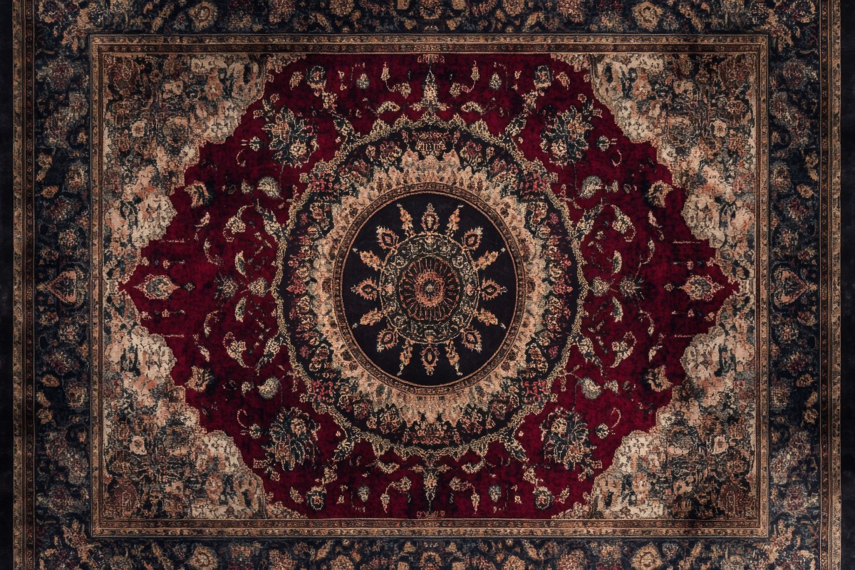 A skilled artisan at Rose Oriental Rugs in Berkeley performing a traditional immersion oriental rug cleaning and washing process in a shallow wash pool on an antique Persian wool rug.