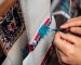 A skilled artisan meticulously re-weaving the fibers of an antique Persian carpet, showcasing expert oriental rug repair near me at Rose Oriental Rugs in Berkeley.