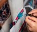 A skilled artisan meticulously re-weaving the fibers of an antique Persian carpet, showcasing expert oriental rug repair near me at Rose Oriental Rugs in Berkeley.