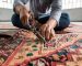Master artisan performing hand-knotted Persian rug repair to restore unraveled fringes and foundation fibers.