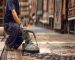Master weaver performing precise Persian rug repair and cleaning on a vintage wool carpet.