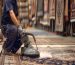 Master weaver performing precise Persian rug repair and cleaning on a vintage wool carpet.