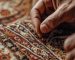 Textile artisan carefully re-weaving damaged wool knots onto an antique foundation for an oriental rug repair near me service.