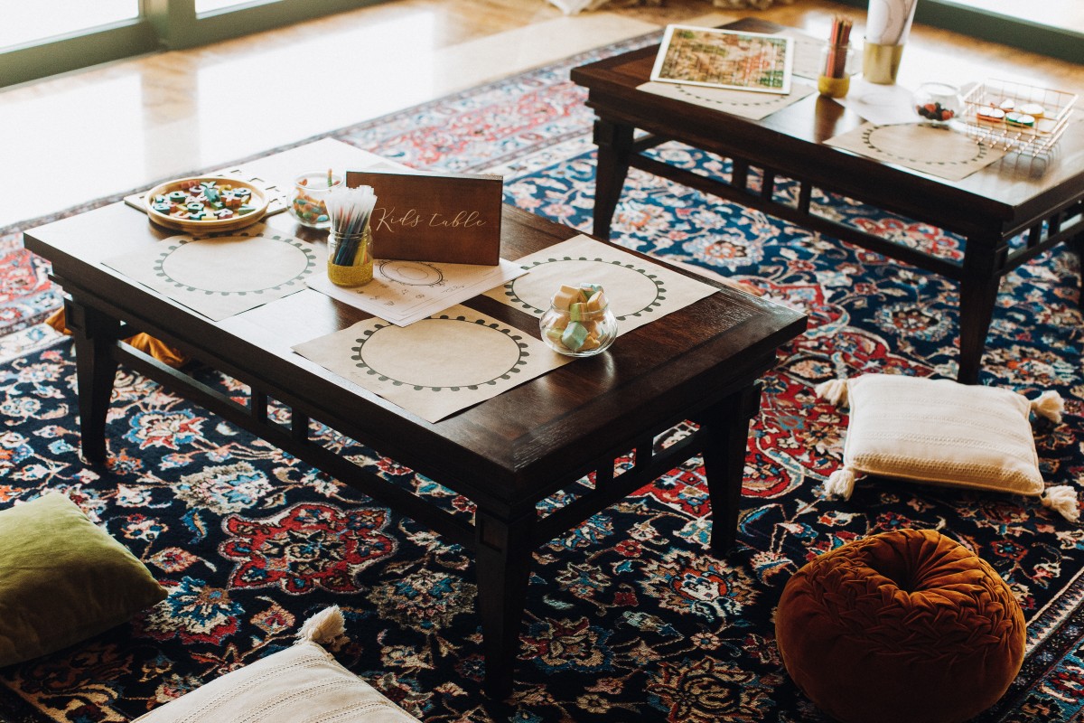Detailed edge binding and stitched fabric border on custom bound carpet rugs over hardwood flooring.